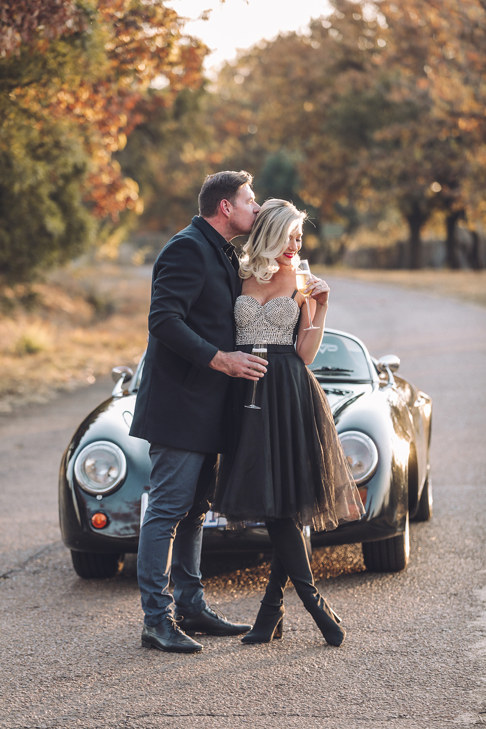 Couple Porsche winding road sparkling wine